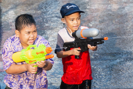 SUKHOTHAI, THAILAND - 15 APRIL 2019: Thai children shooting with water gun during New Year Songkran Water Festivalのeditorial素材