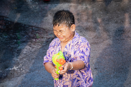SUKHOTHAI, THAILAND - 15 APRIL 2019: Thai children shooting with water gun during New Year Songkran Water Festivalのeditorial素材