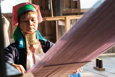 Inle, Myanmar - March 2019: Kayan Lahwi tribe long neck woman sits behind the loom in a tourist shop on Inle lakeのeditorial素材
