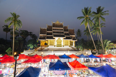 Luang Prabang, Laos - May 2019: night market with Royal palace and national museum on background.のeditorial素材