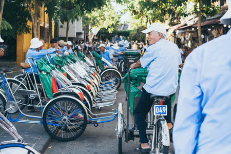 Hoi An, Vietnam - June 2019: bicycle rickshaws transporting tourists in the historic town centerのeditorial素材