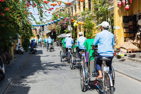 Hoi An, Vietnam - June 2019: bicycle rickshaws transporting tourists in the historic town centerのeditorial素材