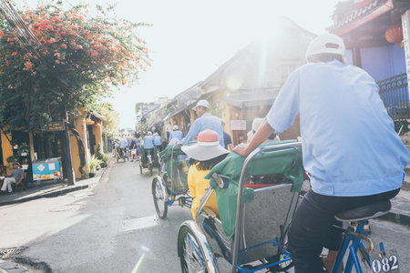 Hoi An, Vietnam - June 2019: bicycle rickshaws transporting tourists in the historic town centerのeditorial素材
