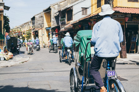 Hoi An, Vietnam - June 2019: bicycle rickshaws transporting tourists in the historic town centerのeditorial素材
