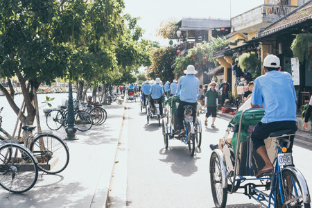 Hoi An, Vietnam - June 2019: bicycle rickshaws transporting tourists in the historic town centerのeditorial素材