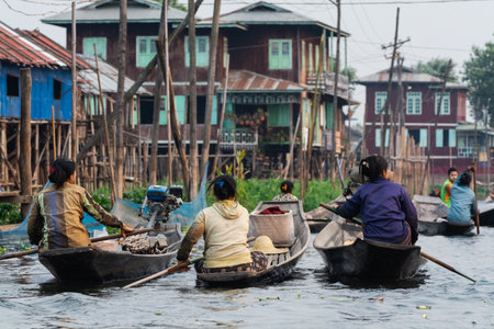 Inle, Myanmar - April 2019: Burmese women rowing boats in Mine Thauk floating villageのeditorial素材