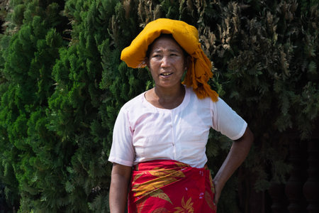 Mandalay, Myanmar - April 2019: portrait of Burmese woman with orange wrap covering head.のeditorial素材