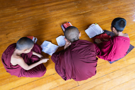 Inle, Myanmar - April 2019: Burmese novice monks reading books in the monasteryのeditorial素材