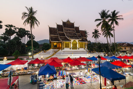 Luang Prabang, Laos - May 2019: night market with Royal palace and national museum on background.のeditorial素材