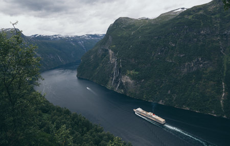 Geiranger, Norway - August 2017: big cruise ship sailing through the fjord nexto to Seven Sisters waterfallのeditorial素材