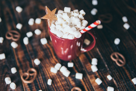 Close-up on hot chocolate mug covered with marshmallow on dark wood backgroundの写真素材