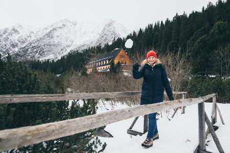 Woman throwing snowball in snowy High Tatra mountains in winter close to Popradske Pleso, Slovakiaの写真素材