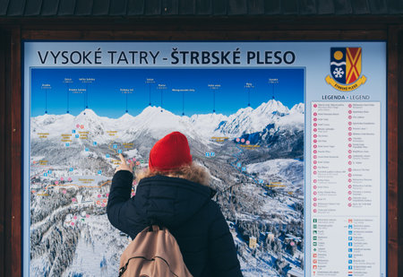 Strbske Pleso, Slovakia - December 2019: woman studying a map of High Tatra mountains near Strbske Plesoのeditorial素材
