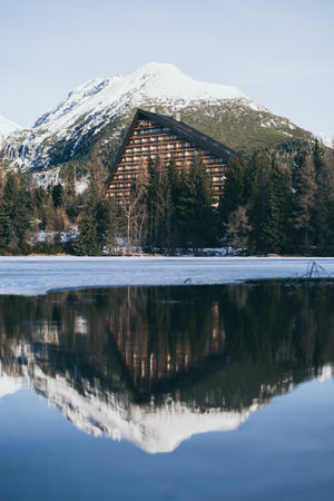 Strbske Pleso, Slovakia - December 2019: view over Patria hotel and High Tatra mountains reflecting in lake water. Vertical orientationのeditorial素材
