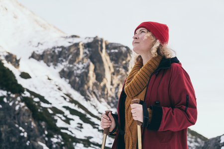 Woman trekking with walking poles in snowy High Tatra mountains in winter, Slovakiaの写真素材