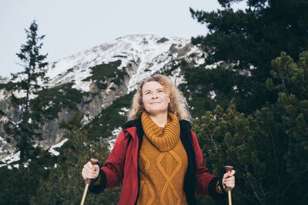 Woman trekking with walking poles in snowy High Tatra mountains in winter, Slovakiaの写真素材