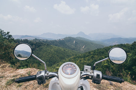 Motorcycle handlebars with Laotian mountains on background close to Luang Prabangの写真素材