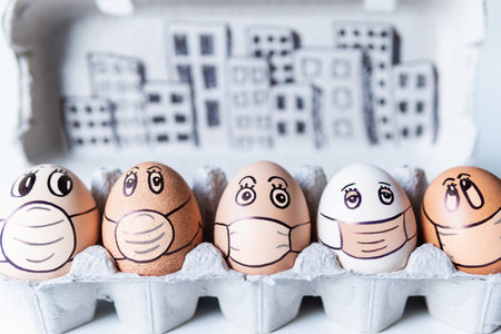 Diverse chicken eggs with doodle faces wearing medical masks with a city skyline on the background. Conceptual image of pollution and epidemyの写真素材