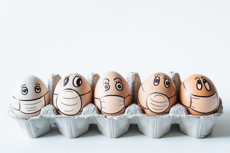 Diverse chicken eggs with doodle faces wearing medical masks with white background. Conceptual image...