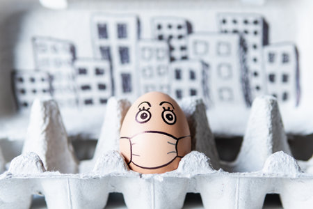 Chicken egg in a tray with doodle face wearing medical mask with city skyline on background....