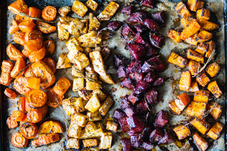 Top down view over flat lay oven tray with baked vegetable mix.の写真素材