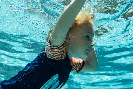 little girl swimming in blue clear water, vacation conceptの写真素材