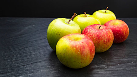 Three ripe fresh green apples and tree red apples on black backgroundの写真素材