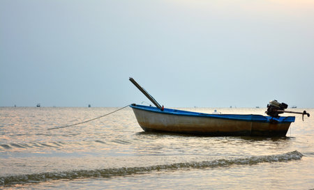 Boat drifting in ocean close to shoreの写真素材