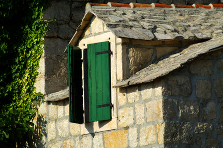 Old window on stone rural house with ivy on bakgroundの写真素材