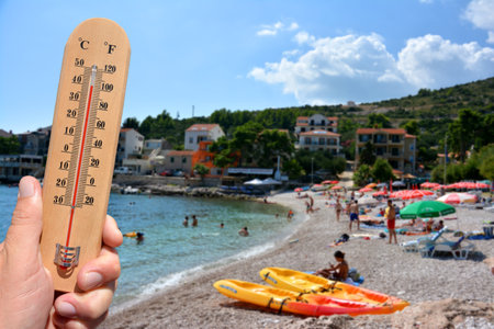 A thermometer scale shows extreme high temperatures during a heat wave and beach in background. Skin...
