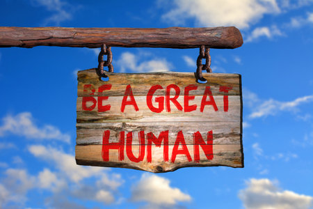 Be a great human motivational phrase sign on old wood with blurred backgroundの写真素材