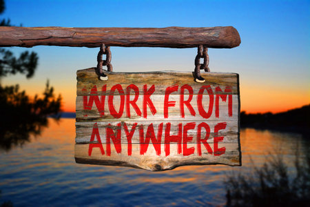 Work from anywhere motivational phrase sign on old wood with blurred backgroundの写真素材