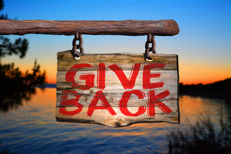 Give back motivational phrase sign on old wood with blurred backgroundの写真素材
