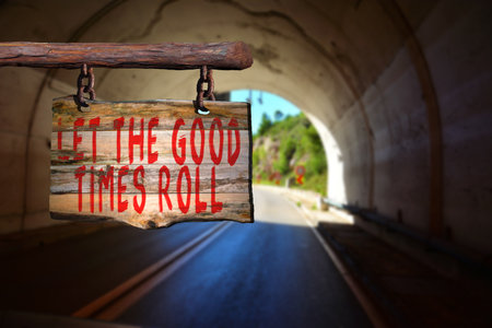 Let the good times roll motivational phrase sign on old wood with blurred backgroundの写真素材