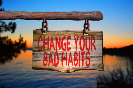 Change your bad habits motivational phrase sign on old wood with blurred backgroundの写真素材