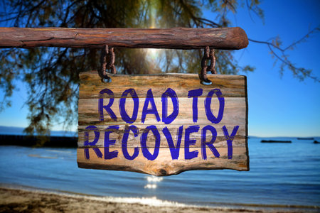 Road to recovery motivational phrase sign on old wood with blurred backgroundの写真素材