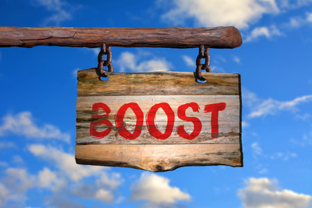 Boost motivational phrase sign on old wood with blurred backgroundの写真素材