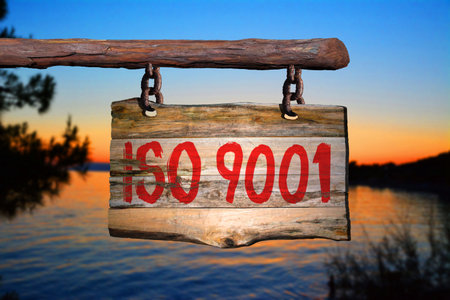 iso 9001 motivational phrase sign on old wood with blurred backgroundの写真素材