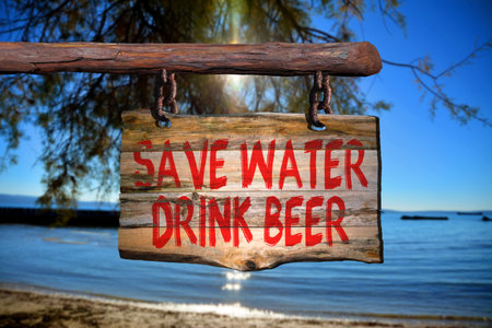 Save water drink beer motivational phrase sign on old wood with blurred backgroundの写真素材