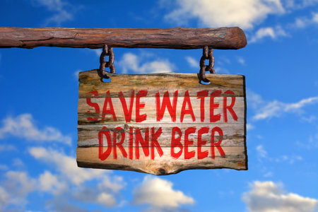 Save water drink beer motivational phrase sign on old wood with blurred backgroundの写真素材