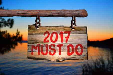 2017 must do motivational phrase sign on old wood with blurred backgroundの写真素材