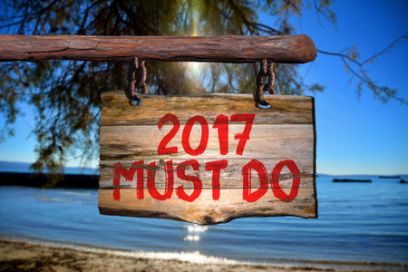 2017 must do motivational phrase sign on old wood with blurred backgroundの写真素材