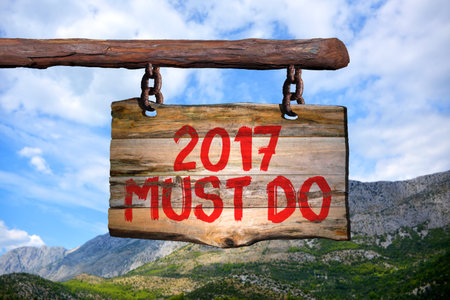 2017 must do motivational phrase sign on old wood with blurred backgroundの写真素材
