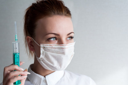 Portrait of a girl in a medical mask. Holding a package of pills in her hand. close upの写真素材