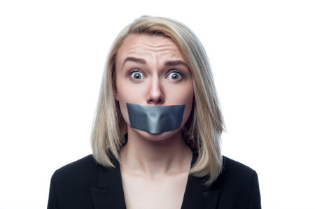Girl with a mouth taped on a white backgroundの写真素材