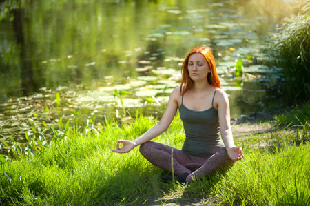Yoga woman meditating at sunset. Women's model of meditation in serene harmonyの写真素材