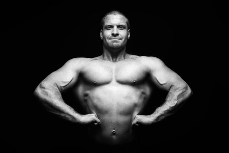 sports man standing on a black background, doing sportsの写真素材