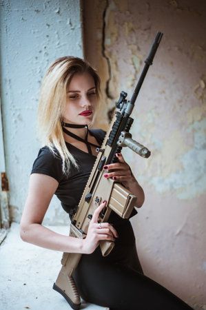 Beautiful portrait of a girl holding a gunの写真素材