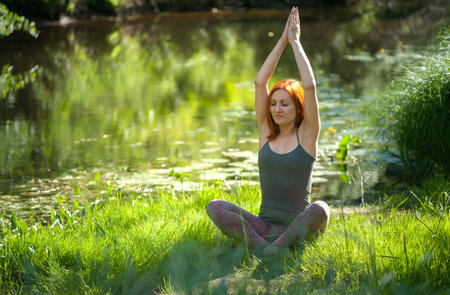 Yoga woman meditating at sunset. Women's model of meditation in serene harmonyの写真素材