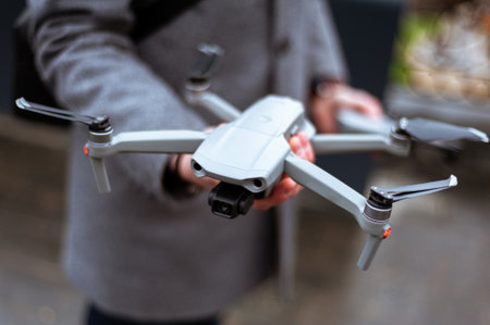 Remote control of the quadcopter. The operator controls the drone. The phone on the remote control. Quadrotor filming. Fingers on the joystick controlの写真素材